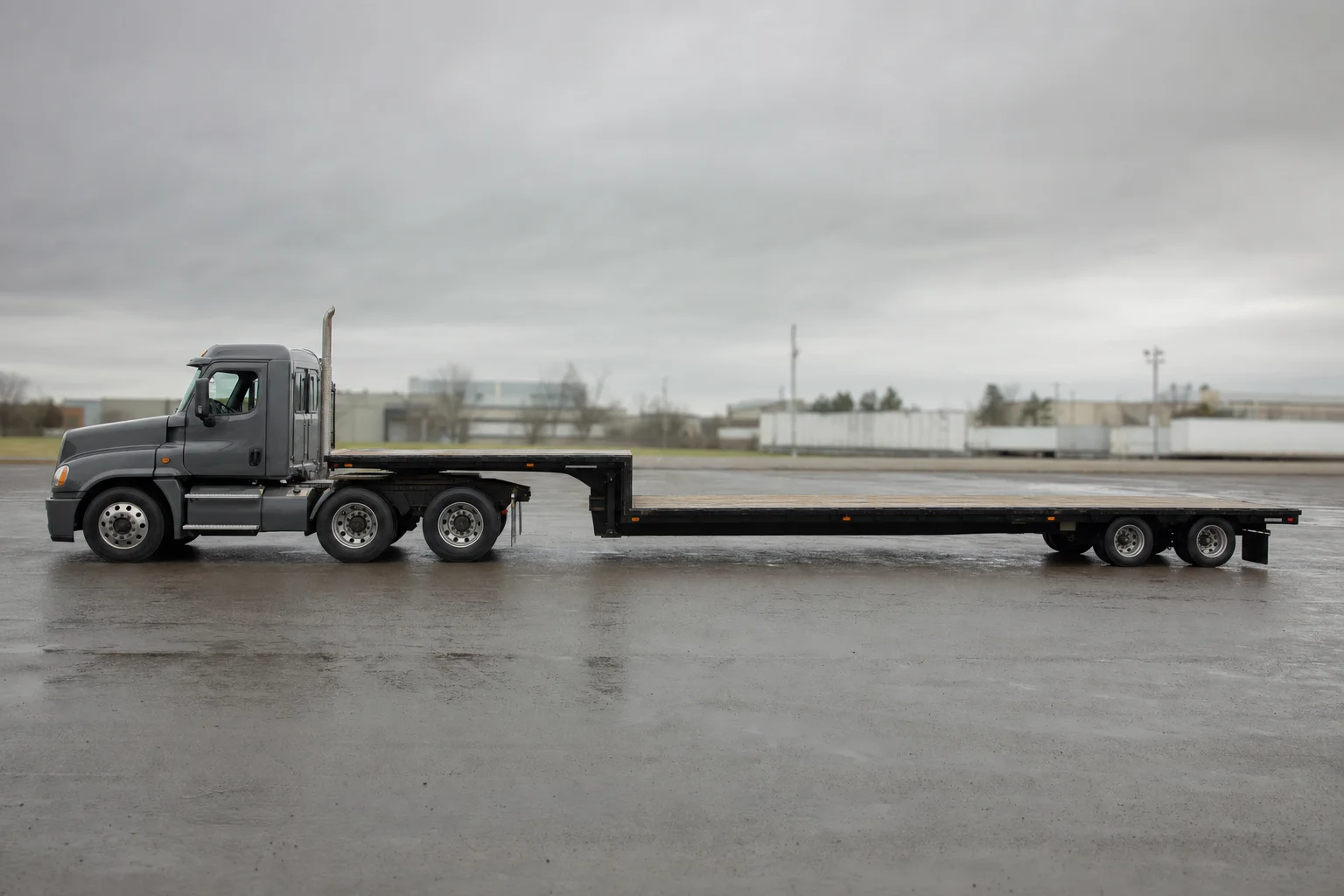 Step-deck trailer showing the upper deck and long lower deck, side profile